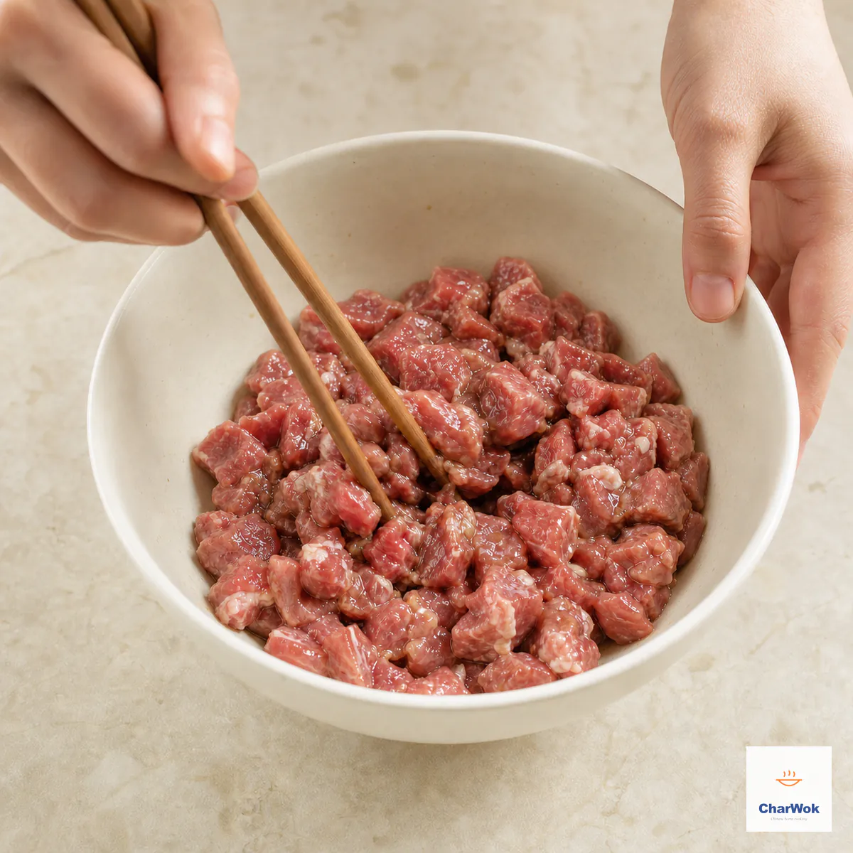 Chopsticks stir evenly diced raw lamb coated in a thin moist marinade with no free liquid visible at the bottom of the bowl