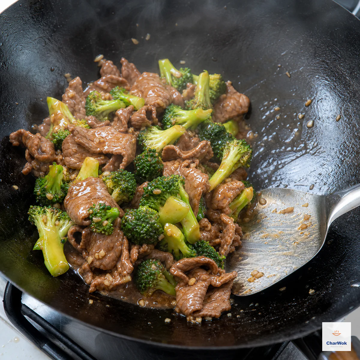 Beef and bright-green broccoli are tossed with minced aromatics in a wok as thin glossy brown sauce clings and remains slightly loose at the bottom