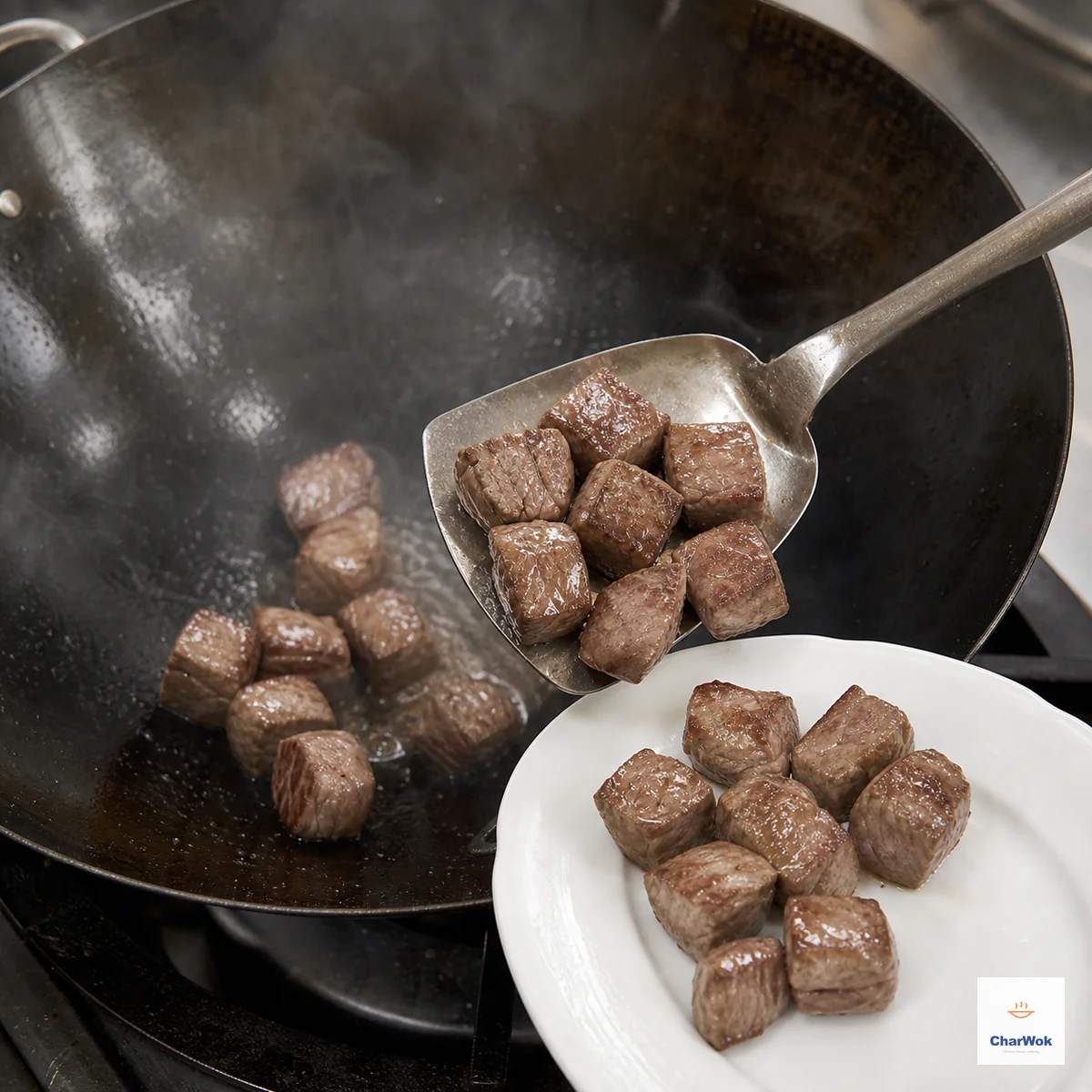 Moist beef cubes with fully opaque warm-brown surfaces are lifted from a hot wok onto a white plate with no visible pink outside