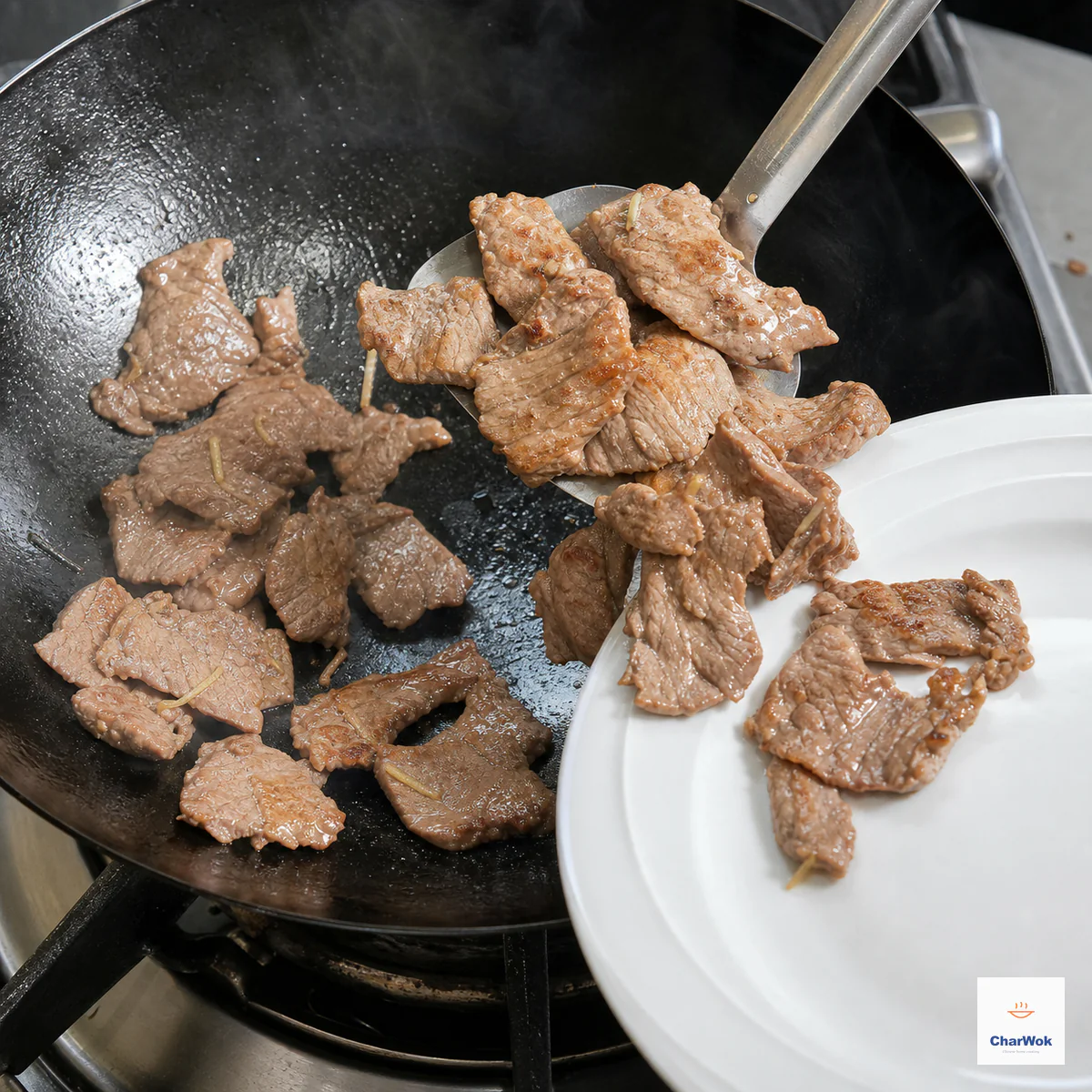Thin beef slices with light-golden contact patches and no visible pink are lifted from a hot wok