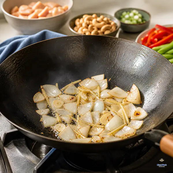 Garlic, ginger, and onion petals stir-fry in the cashew-scented wok oil until the onion edges soften and take on a few golden char spots