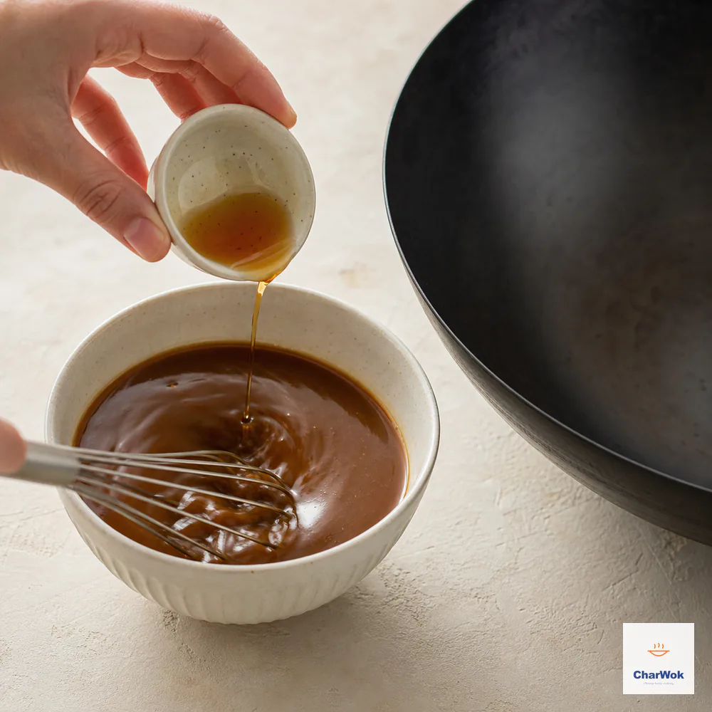 A small whisk blends the soy, oyster, starch, pepper, sugar, and water sauce completely smooth while amber toasted sesame oil is added last