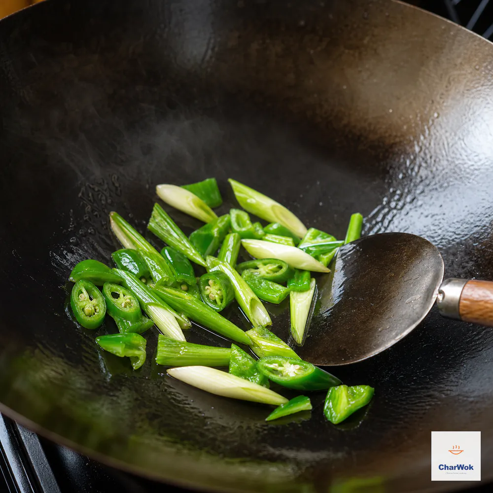 Bright green scallion sections and green chili or green bell pepper pieces toss alone in a carbon-steel wok until glossy and just beginning to bend