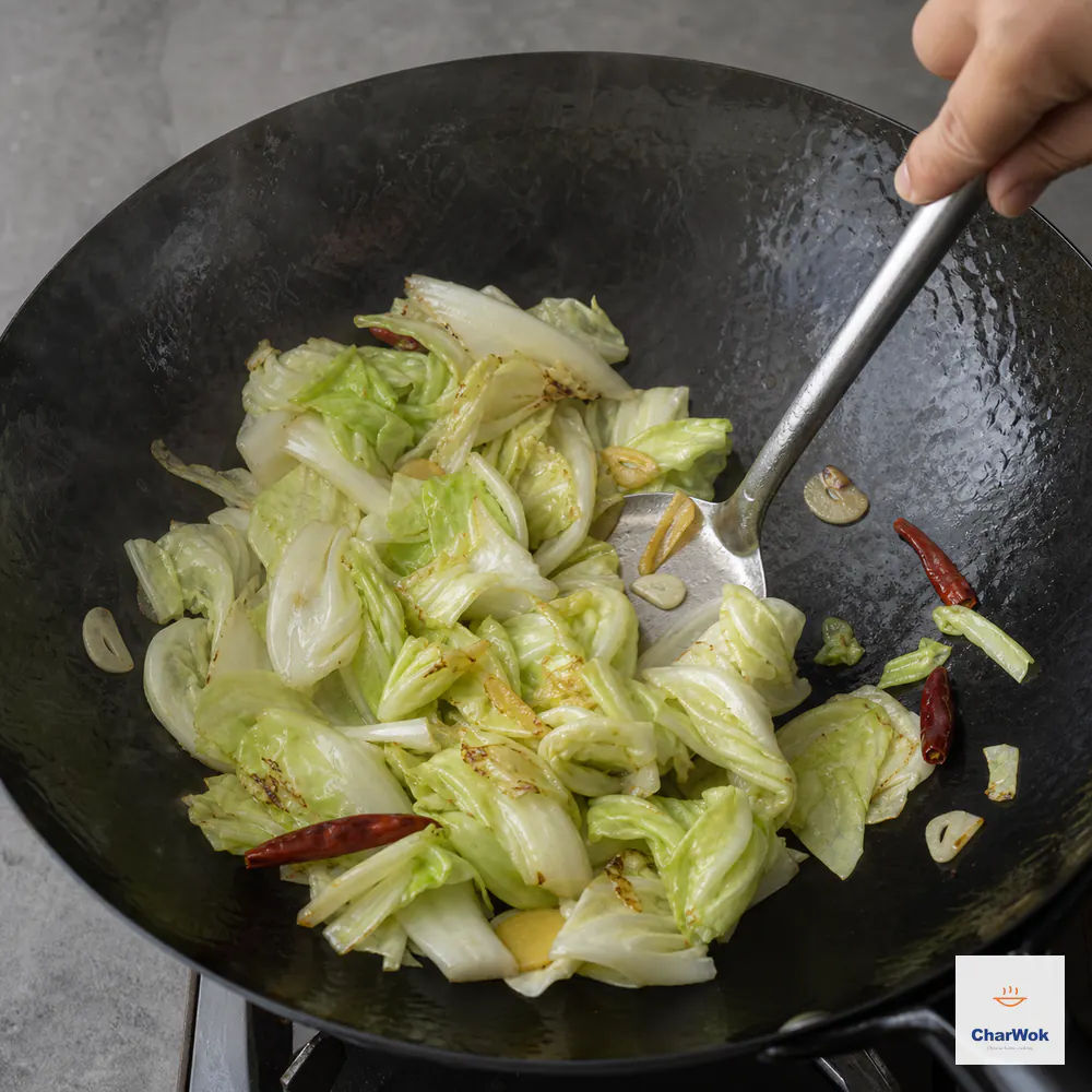 Hand-torn cabbage is tossed over high heat until reduced to about two-thirds, with bright crisp centres, lightly charred edges, and no pooled water