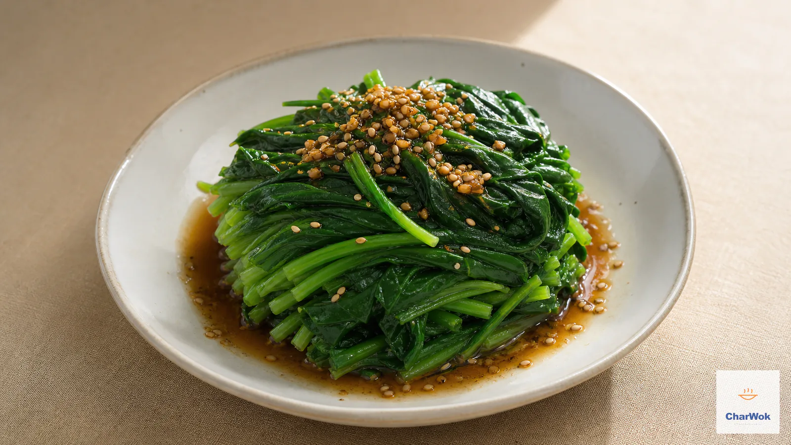 Compact mound of vivid green blanched spinach with ginger dressing and toasted sesame seeds