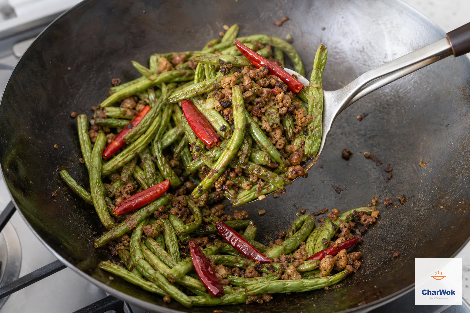 Wrinkled blistered green beans are tossed with browned pork, ya cai, peppercorn and six dried chilies over a visibly dry wok bottom