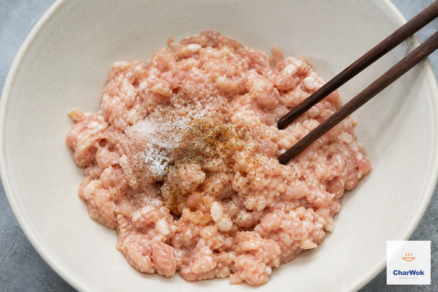 Raw ground chicken thigh is mixed with salt, ground spice and a restrained amount of light soy before any liquid or vegetables