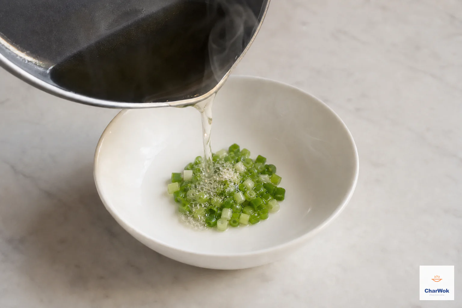 Hot neutral oil sizzles locally over one tablespoon of chopped scallion while the green and white pieces remain vivid