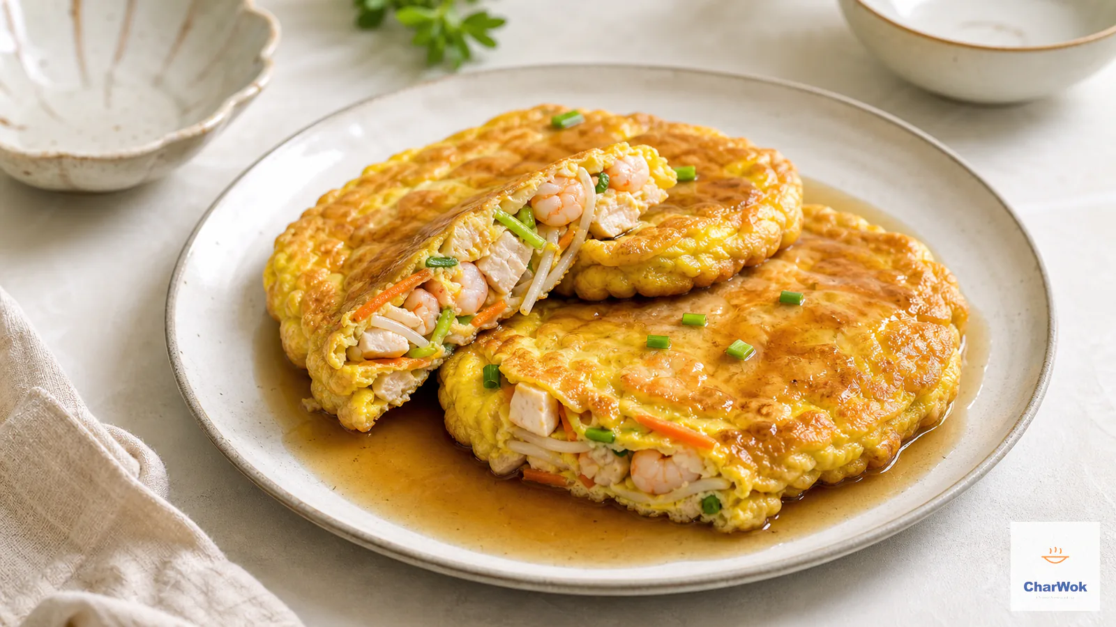 Deep-golden egg foo young patties with shrimp, chicken, bean sprouts and carrot under light-brown gravy
