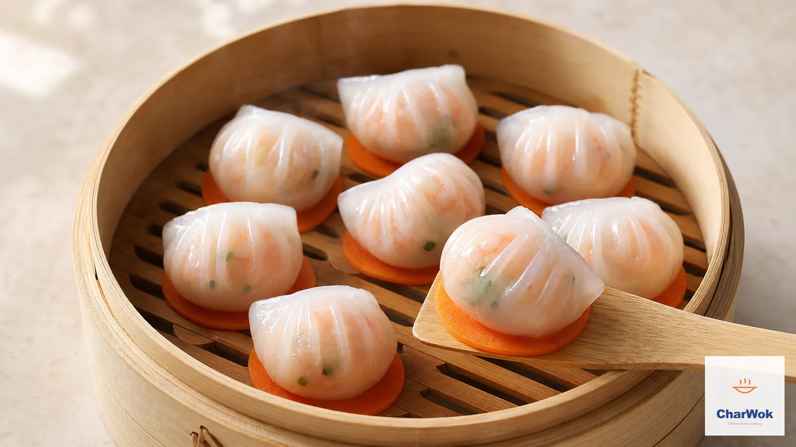 Freshly steamed Cantonese har gow in a bamboo steamer, with translucent pleated wrappers showing pink whole shrimp and chives, each dumpling resting on a carrot slice