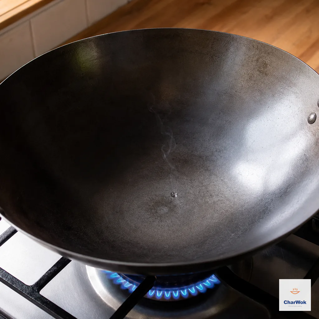 A water droplet dances in an empty carbon-steel wok that has just begun to smoke over a strong blue flame
