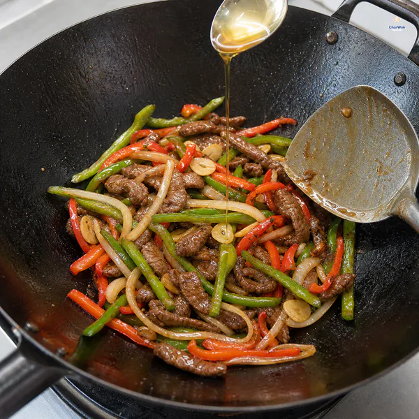 Pepper steak carries a thin clear glossy brown coating as sesame oil is drizzled over the finished beef and long pepper strips