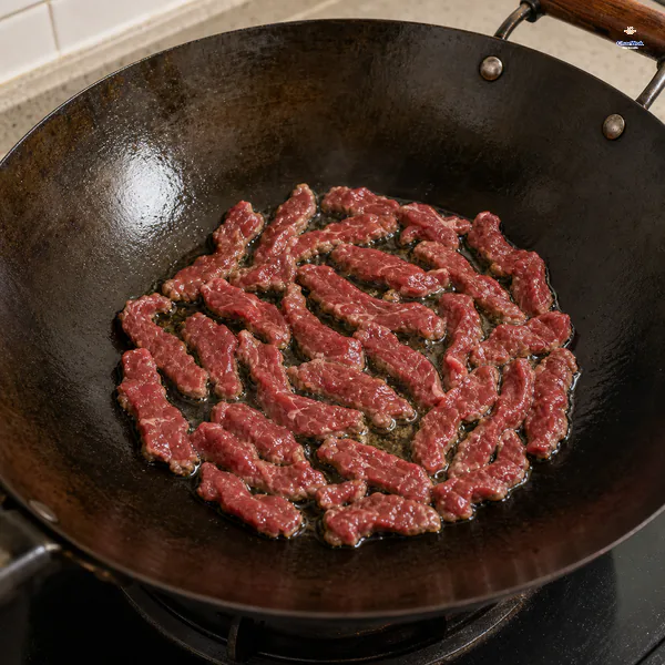 Marinated beef strips sear untouched in one uncrowded layer with red tops and lightly browned undersides