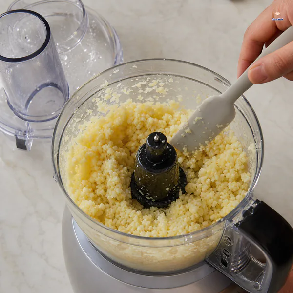 Garlic and ginger have been pulsed in a food processor into a moist rough paste with visible tiny pieces