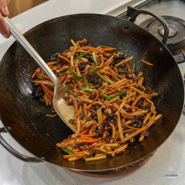 Pork, carrot, wood ear and bamboo shoots carry a thin glossy reddish-brown coating as the wok rests off the flame