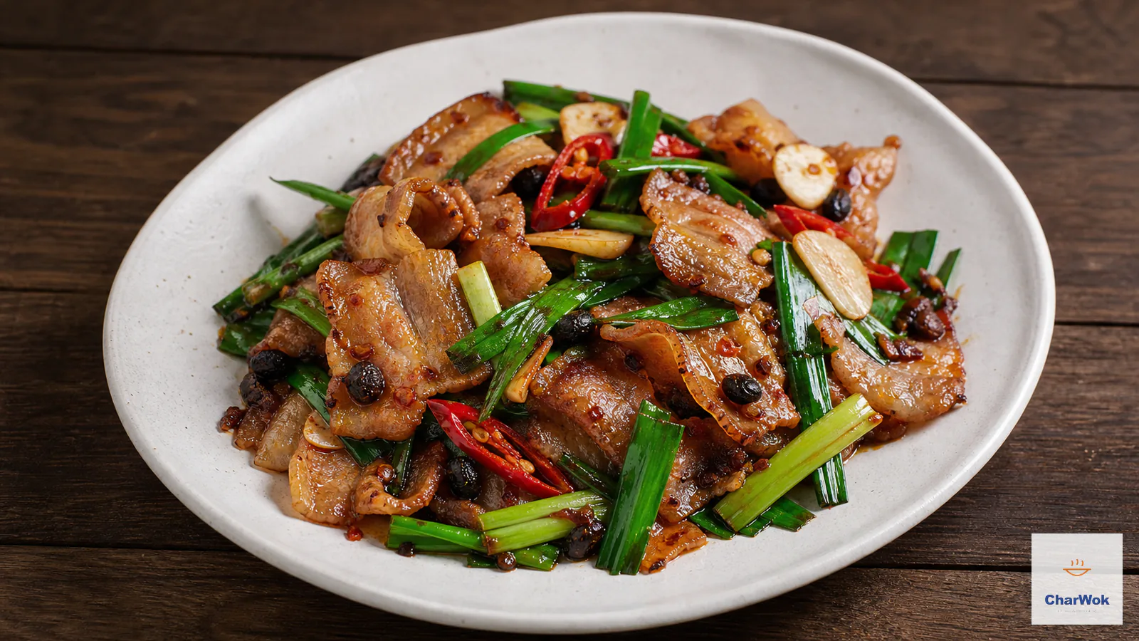 Twice-cooked pork with curled thin pork-belly slices lacquered in red chili-bean sauce with green leek and fresh red chili